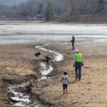 Volunteers explore the dry lakebed during a lake cleanup