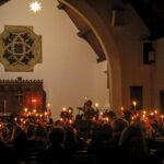 Candlelight service attendees raise their lighted candles inside Memorial Chapel