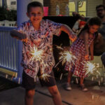 Kids enjoy sparklers at a family reunion during Independence DAy